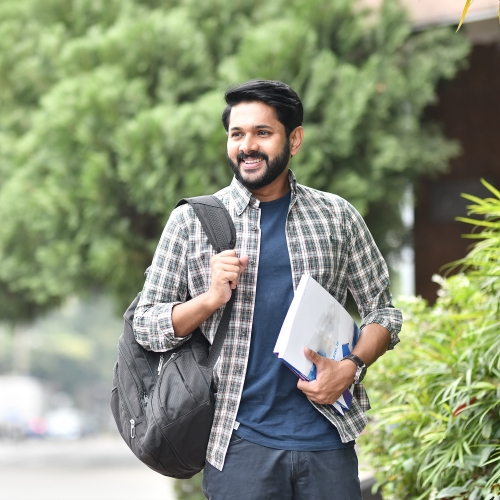 a student holding a book and a backpack